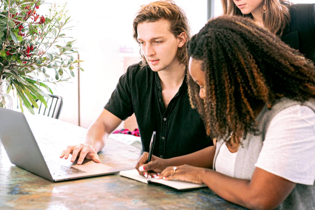 man-working-on-laptop-while-woman-takes-notes-