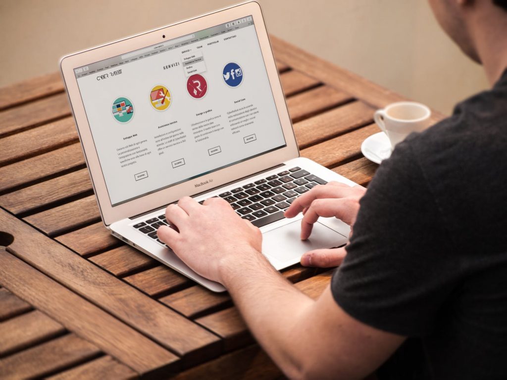 man at computer looking at social media sites